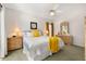 Bedroom showcasing natural light, dresser, and bed adorned with yellow throw blanket and pillows at 4640 Eagle Peak Dr, Kissimmee, FL 34746