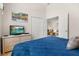 Cozy bedroom featuring a dresser with a television and a bright blue bed at 4640 Eagle Peak Dr, Kissimmee, FL 34746