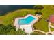 A scenic aerial shot of a hexagonal community pool with lounge area by a pond at 4640 Eagle Peak Dr, Kissimmee, FL 34746