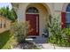 Inviting front entrance with a red door, arched window, and lush landscaping at 4640 Eagle Peak Dr, Kissimmee, FL 34746