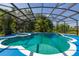 Screened pool with attached hot tub and views of lush tropical landscaping at 4640 Eagle Peak Dr, Kissimmee, FL 34746