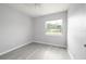 Cozy bedroom with grey laminate flooring, a ceiling fan, and large window at 4824 Shoshone St, Orlando, FL 32819