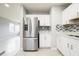 Modern kitchen with stainless steel refrigerator, white cabinets, and stylish backsplash at 4824 Shoshone St, Orlando, FL 32819