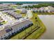 An aerial view of a residential community with modern townhomes, green spaces and a scenic lake at 4829 Cedar Bay Ter, Kissimmee, FL 34746