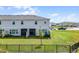 The back of this townhome has a screened porch and a grassy yard, enclosed by a sleek, black metal fence at 4829 Cedar Bay Ter, Kissimmee, FL 34746