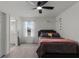 Comfortable bedroom featuring gray carpet, a ceiling fan, and a view into the bathroom with a decorative window at 4829 Cedar Bay Ter, Kissimmee, FL 34746