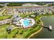 Aerial view of a community pool featuring a splashpad, seating, and lake access with scenic views at 4829 Cedar Bay Ter, Kissimmee, FL 34746