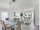 Elegant dining and living area featuring a stylish chandelier, glass table, and comfortable seating with lots of natural light at 4829 Cedar Bay Ter, Kissimmee, FL 34746