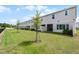 Back exterior view of townhomes with well-maintained lawns and young trees, enhancing curb appeal and outdoor enjoyment at 4829 Cedar Bay Ter, Kissimmee, FL 34746
