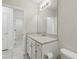 Bright bathroom with a large mirror, white vanity, and tile flooring at 5079 Royal Point Ave, Kissimmee, FL 34746