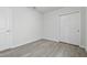 A clean and modern bedroom with light gray vinyl flooring and a closet at 5079 Royal Point Ave, Kissimmee, FL 34746