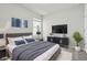 Modern bedroom with a gray bed, mounted TV, and stylish décor, perfect for relaxing and unwinding after a long day at 5079 Royal Point Ave, Kissimmee, FL 34746