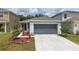 This home offers a large driveway, a two-car garage, manicured landscaping, and a neutral color palette at 5079 Royal Point Ave, Kissimmee, FL 34746
