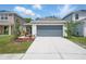 This single-Gathering home features a large driveway, two-car garage, and lush landscaping at 5079 Royal Point Ave, Kissimmee, FL 34746