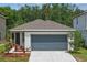 Charming single-story home featuring a two-car garage, neutral paint, and landscaped flower beds at 5079 Royal Point Ave, Kissimmee, FL 34746