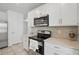 Bright kitchen features white cabinetry, stainless steel microwave, and tile backsplash at 5079 Royal Point Ave, Kissimmee, FL 34746