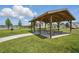 Community outdoor pavilion with picnic tables, ideal for gatherings and overlooking a tranquil lake at 5079 Royal Point Ave, Kissimmee, FL 34746