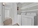 Functional laundry room with washer, dryer, and overhead shelving for convenient storage at 514 Orange Dr # 31, Altamonte Springs, FL 32701