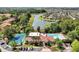 Aerial view showcasing a community pool, clubhouse, tennis court, and scenic lake at 5168 Conroy Rd # 35, Orlando, FL 32811