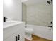 Bathroom with white vanity, black hardware, and a white tub with marble-look tiling at 5168 Conroy Rd # 35, Orlando, FL 32811