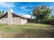 A spacious backyard featuring the home's exterior, including a screened-in back porch, siding, and chimney at 5311 Ansonia Ct, Orlando, FL 32839