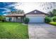 Charming single-story home with a well-maintained lawn and a two-car garage in a suburban neighborhood at 5311 Ansonia Ct, Orlando, FL 32839
