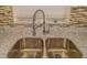 Close up on updated kitchen sink, faucet, granite countertop and tiled backsplash at 5311 Ansonia Ct, Orlando, FL 32839