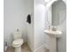 Neat half bathroom with a pedestal sink, round mirror, and a toilet at 5772 Laurel Cherry Ave, Winter Garden, FL 34787
