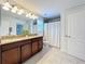 Bright bathroom featuring a double sink vanity with granite countertop and a shower with a bathtub at 5772 Laurel Cherry Ave, Winter Garden, FL 34787