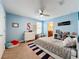 Bedroom with pale blue walls, ceiling fan, and a large bed with a blue and white rug at 5772 Laurel Cherry Ave, Winter Garden, FL 34787