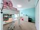 Bright bedroom featuring a loft bed with desk, a bookshelf and an aqua accent wall at 5772 Laurel Cherry Ave, Winter Garden, FL 34787