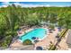 Large community pool with ample lounge chairs, shade umbrellas, and views of the surrounding lake and trees at 5772 Laurel Cherry Ave, Winter Garden, FL 34787