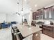 Open kitchen with granite island, stainless appliances, and a view of the living area at 5772 Laurel Cherry Ave, Winter Garden, FL 34787
