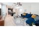 Bright, open living space with stylish blue sofa, modern rug, and a view of the kitchen and dining area at 5772 Laurel Cherry Ave, Winter Garden, FL 34787