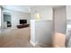 Upstairs loft area with a TV, carpet flooring, and views into an adjacent bedroom and stairway at 5772 Laurel Cherry Ave, Winter Garden, FL 34787