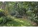 Serene backyard retreat with lush greenery, mature trees, and a tranquil seating area at 628 Riverpark Cir, Longwood, FL 32779