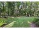 Spacious backyard with a seating area, lush lawn, and mature trees offering ample shade at 628 Riverpark Cir, Longwood, FL 32779