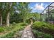 Idyllic backyard features a stone path leading to a screened-in enclosure at 628 Riverpark Cir, Longwood, FL 32779
