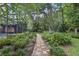 Beautiful backyard with a stone path, lush landscaping, and a screened porch at 628 Riverpark Cir, Longwood, FL 32779