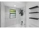Bathroom featuring tiled walls, glass shower, and decorative floating shelves at 628 Riverpark Cir, Longwood, FL 32779