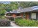 Charming brick home with a well-manicured yard and solar panels on the roof at 628 Riverpark Cir, Longwood, FL 32779