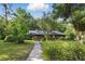 Traditional brick home featuring lush landscaping, solar panels, and a welcoming walkway at 628 Riverpark Cir, Longwood, FL 32779