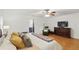 A well-lit primary bedroom has hardwood floors, a ceiling fan, and a sitting area with leather chair at 628 Riverpark Cir, Longwood, FL 32779