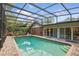 Enclosed pool area with a lounge area, brick trim, and view of the backyard at 628 Riverpark Cir, Longwood, FL 32779