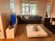 Living room featuring plush sofas, a white coffee table, a TV, and large windows with natural light at 6450 Alcalde Ct # 106, Orlando, FL 32835