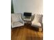 Comfortable living space featuring tufted accent chairs, wood floors, and a stylish side table with lamp at 6450 Alcalde Ct # 106, Orlando, FL 32835