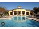 Bright yellow community clubhouse with a clear blue swimming pool and plenty of patio seating at 6450 Alcalde Ct # 106, Orlando, FL 32835