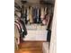 Organized walk-in closet with hanging racks, shelving, and a white six-drawer dresser with storage boxes at 6450 Alcalde Ct # 106, Orlando, FL 32835