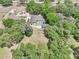 An aerial view of a home with a pool and detached garage, surrounded by mature trees and lush landscaping at 6686 Se 135Th St, Summerfield, FL 34491