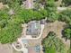 Aerial of a beautiful house with a pool and a well-manicured yard surrounded by lush trees at 6686 Se 135Th St, Summerfield, FL 34491